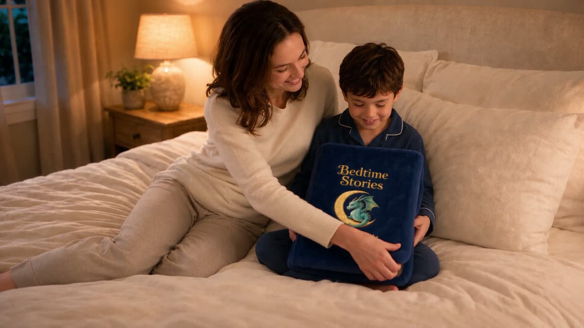 Mom and son unfolding the BlankyBook Moon Dragon storybook blanket on a bed at bedtime